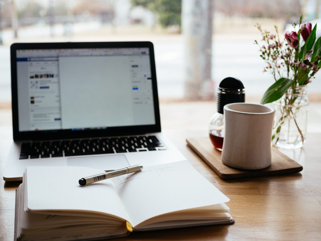 image of a desk with a laptop and notebook